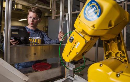 一名工业工程专业的学生正在测试用于制造业的机械臂.